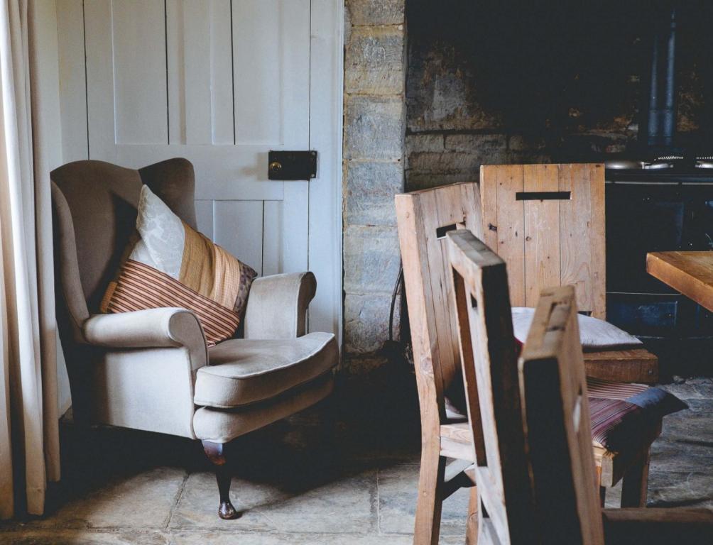 beżowy fotel i drewniane krzesła