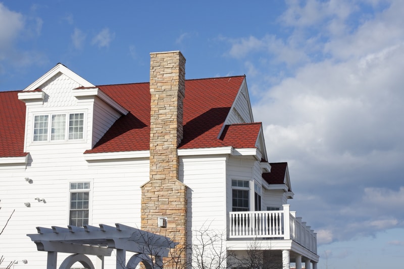 zewnętrzny komin z cegły na białym domu